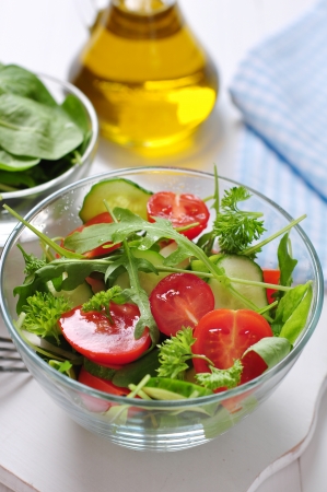 fresh salad with tomatoes cherry, arugula and cucumber in glass bowlの写真素材