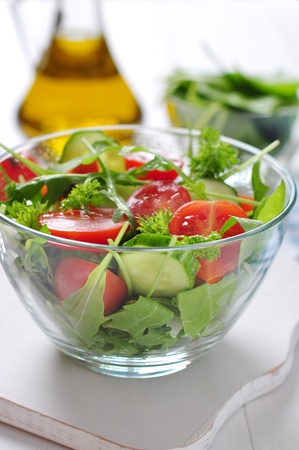 fresh salad with tomatoes cherry, arugula and cucumber in glass bowlの写真素材