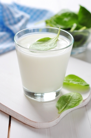 Yogurt with spinach in a glass on wooden cutting boardの写真素材