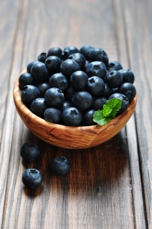 Fresh blueberry in wooden bowl on wooden backgroundの写真素材