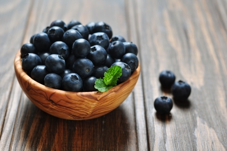 Fresh blueberry in wooden bowl on wooden backgroundの写真素材