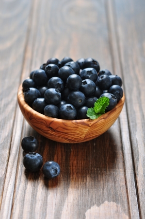 Fresh blueberry in wooden bowl on wooden backgroundの写真素材
