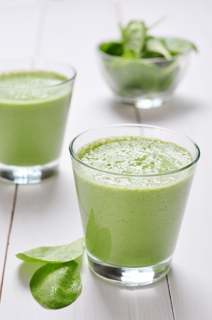 Spinach smoothies in glass on a wooden backgroundの写真素材