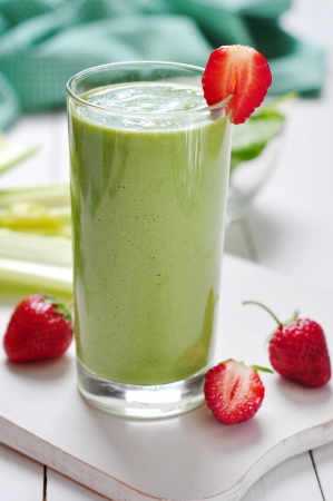 Green vegetable smoothie with celery and strawberry on wooden backgroundの写真素材