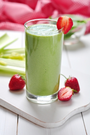 Green vegetable smoothie with celery and strawberry on wooden backgroundの写真素材