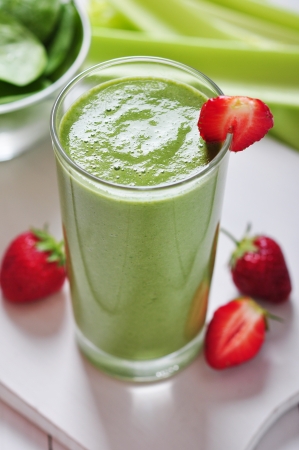 Green vegetable smoothie with celery and strawberry on wooden backgroundの写真素材