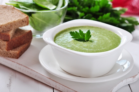 spinach soup in a bowl on a wooden backgroundの写真素材