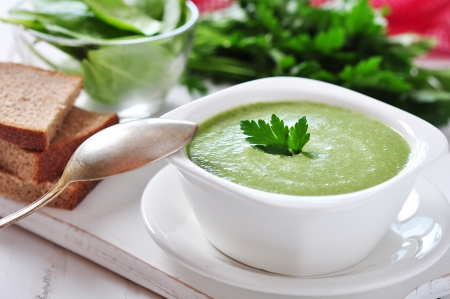 spinach soup in a bowl on a wooden backgroundの写真素材