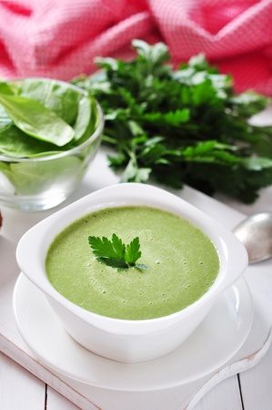 spinach soup in a bowl on a wooden backgroundの写真素材