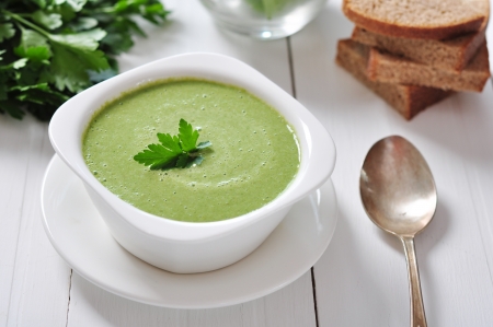 spinach soup in a bowl on a wooden backgroundの写真素材