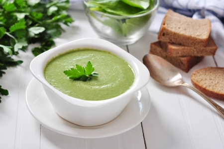 spinach soup in a bowl on a wooden backgroundの写真素材