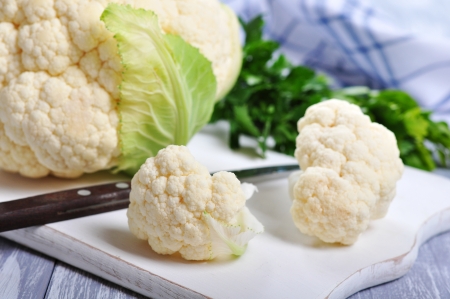 close up on fresh whole cauliflower on cutting boardの写真素材
