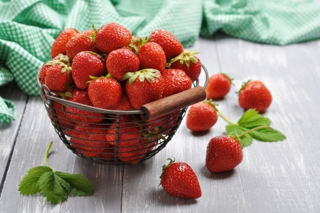 Fresh red strawberries in a  metal basket on wooden backgroundの写真素材