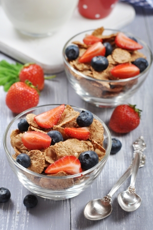 Glass bowl with healthy muesli and fresh berries on a wooden backgroundの写真素材