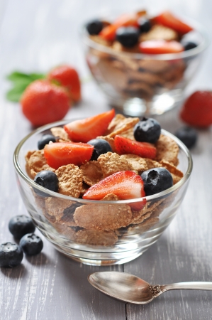 Glass bowl with healthy muesli and fresh berries on a wooden backgroundの写真素材