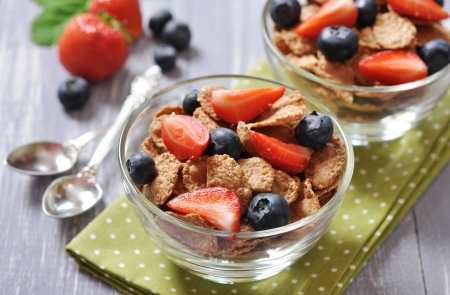 Glass bowl with healthy muesli and fresh berries on a wooden backgroundの写真素材