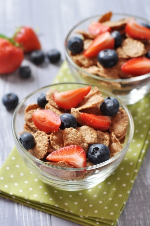 Glass bowl with healthy muesli and fresh berries on a wooden backgroundの写真素材