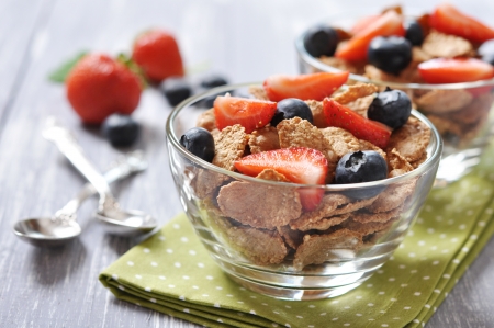 Glass bowl with healthy muesli and fresh berries on a wooden backgroundの写真素材