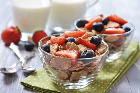 Glass bowl with healthy muesli and fresh berries on a wooden backgroundの写真素材