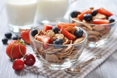 Glass bowl with healthy muesli and fresh berries on a wooden backgroundの写真素材