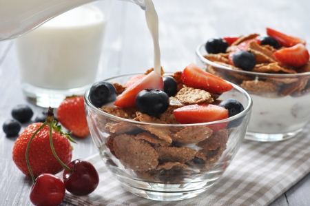 Glass bowl with healthy muesli and fresh berries on a wooden backgroundの写真素材