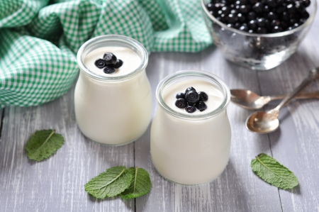 yogurt with ripe fresh blueberry in jars on wooden backgroundの写真素材