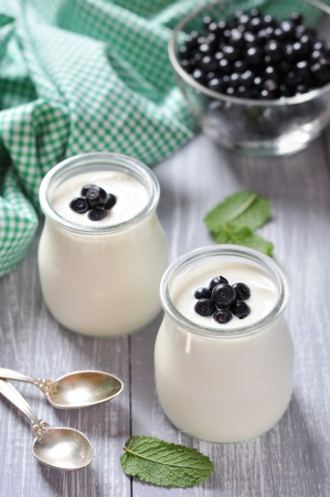 yogurt with ripe fresh blueberry in jars on wooden backgroundの写真素材