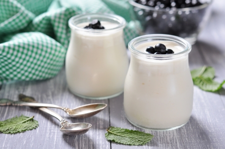 yogurt with ripe fresh blueberry in jars on wooden backgroundの写真素材