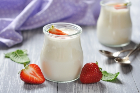 yogurt with ripe fresh strawberry in jars on wooden backgroundの写真素材