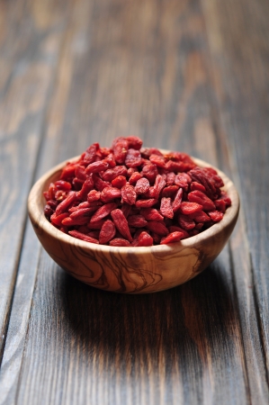 wooden bowl with goji berries on the table closeupの写真素材