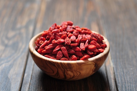 wooden bowl with goji berries on the table closeupの写真素材