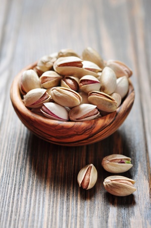 close up of a bowl of pistachio nuts over wooden backgroundの写真素材
