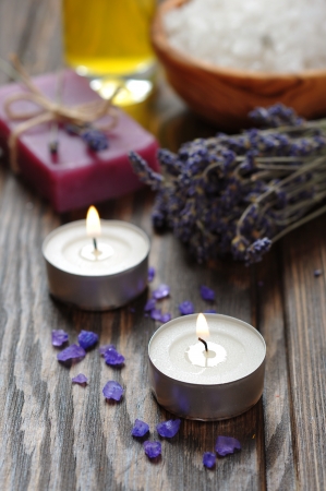 candles, herbal soap with oil, sea salt and lavander flowers on wooden backgroundの写真素材