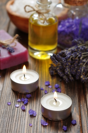 candles, herbal soap with oil, sea salt and lavander flowers on wooden backgroundの写真素材