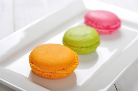 Orange, pink and green macaroons  on white plateの写真素材