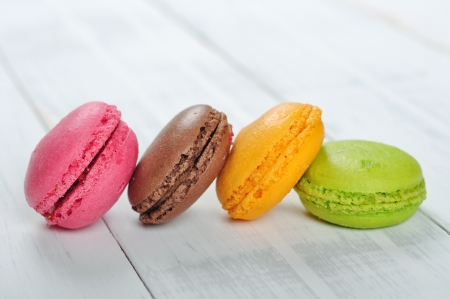 Colorful macaroons isolated over white wooden backgroundの写真素材
