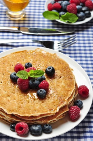 Delicious pancakes close up, with fresh blueberries, raspberry and maple syrupの写真素材