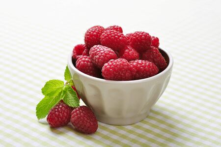 bowl of raspberry on green checkered backgroundの写真素材
