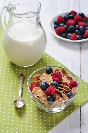cereal flakes with raspberry and blueberry in glass bowlの写真素材