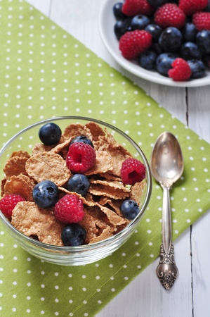 cereal flakes with raspberry and blueberry in glass bowlの写真素材