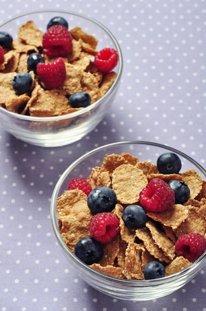 cereal flakes with raspberry and blueberry in glass bowlの写真素材