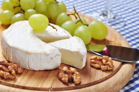 Camembert on wooden cutting board with grape and walnut closeupの写真素材