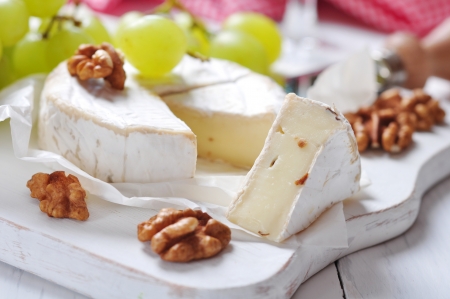 Camembert on wooden cutting board with grape and walnut closeupの写真素材