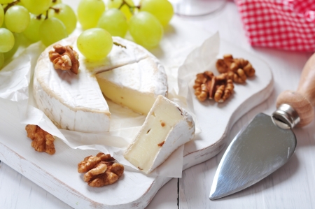 Camembert on wooden cutting board with grape and walnut closeupの写真素材