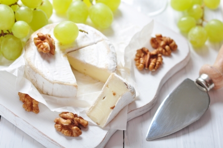 Camembert on wooden cutting board with grape and walnut closeupの写真素材
