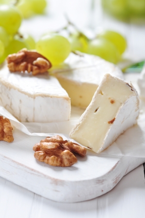 Camembert on wooden cutting board with grape and walnut closeupの写真素材