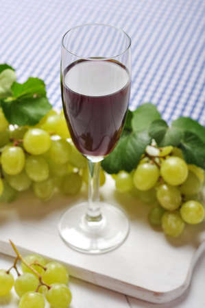 Red wine and grapes on cutting boardの写真素材