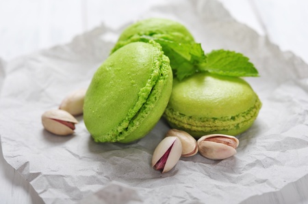 Green macaroons with pistachio over wooden backgroundの写真素材