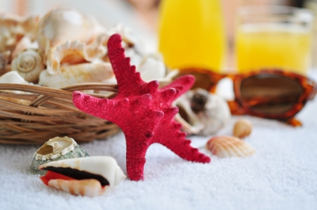 Basket with sea shells, sunglasses and orange juice.の写真素材