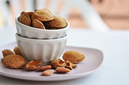 Almonds nuts in ceramic bowl on white backgroundの写真素材
